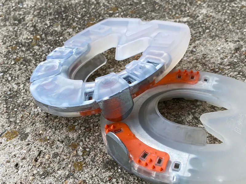 Advantages and special features of the Duplo Arizona horseshoes shown on the shoe placed on stones: steel edge in the toe area, quarter clips, reinforced tread, and frog support.