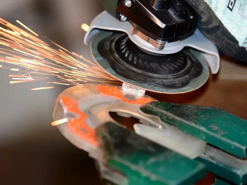 grinding of the quarter clips on a hybrid urethane horse shoe with metal inlay