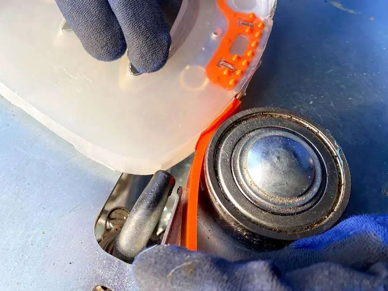 an orange colored strip is welded to a composite horseshoe using a special device