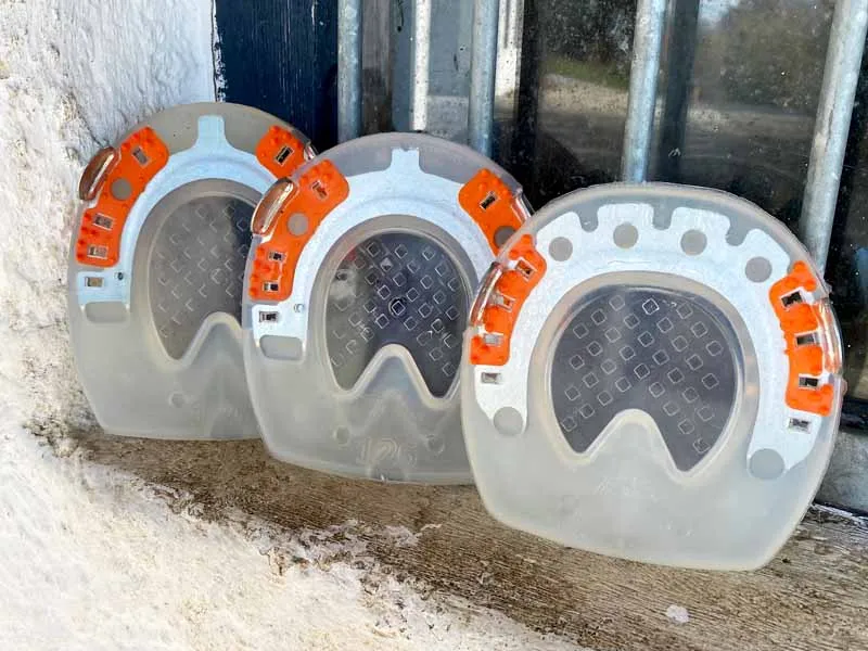 Various shapes of the composite horseshoe with integrated hoof pad – round and straight-toe versions for front hooves, and an oval shape for hind hooves.