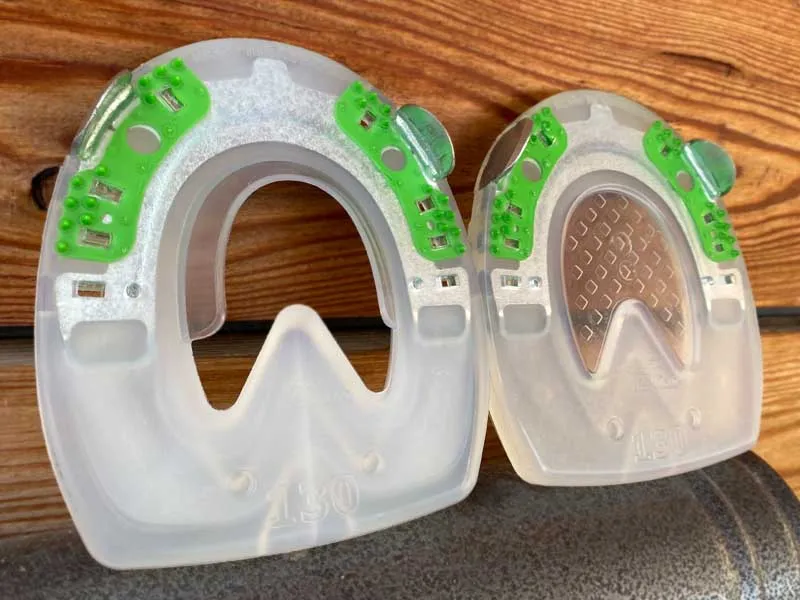 Two types of horseshoes - one with an open sole area, and another with an integrated hoof pad for use with padding material.