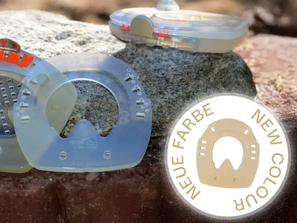 Image to illustrate the new beige color of the wedge soles for composite horseshoes with shock-absorbing synthetic coating. In the background, horseshoes and wedges are placed on a stone surface.