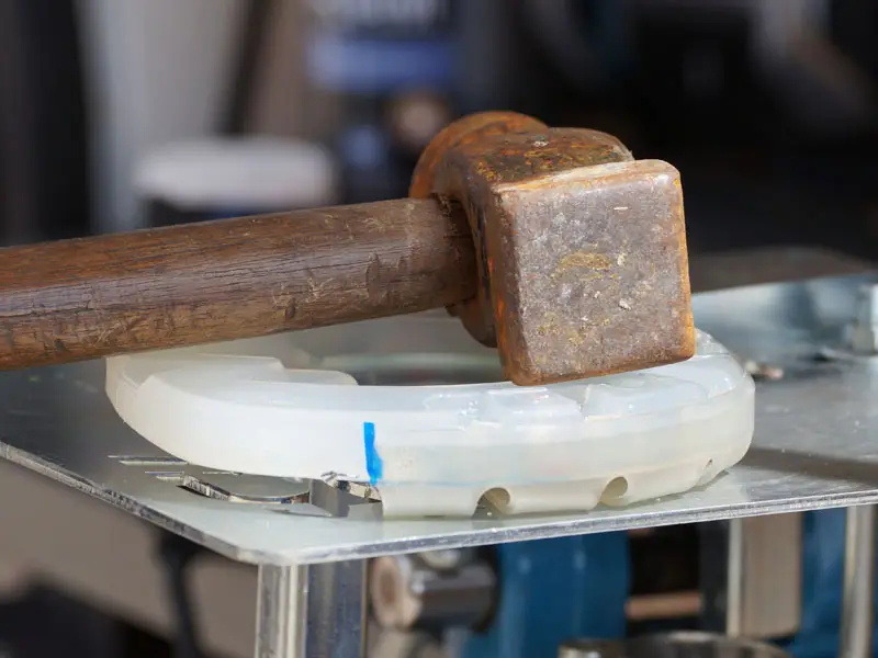Hammer resting on adhesive hoof protection made of a Classic plastic shoe and an Easy adhesive collar.