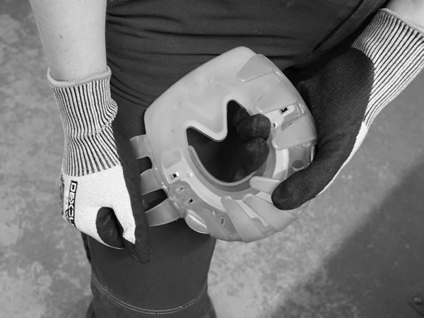 A hand pulls with full force on the adhesive collar tabs of the glue-on urethane horse shoe to test the stability of the weld seam.