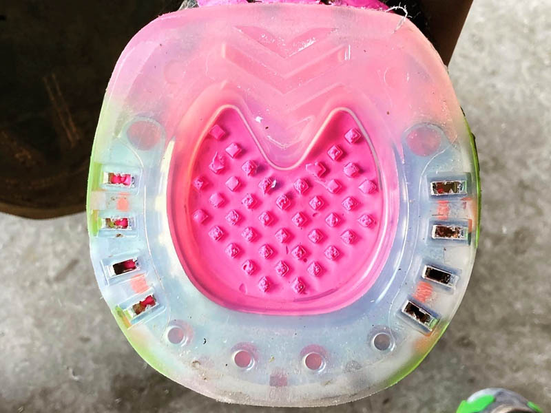 composite horseshoe with a closed sole and pink padding material