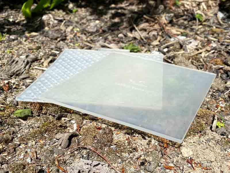 square plastic plates lie on stones