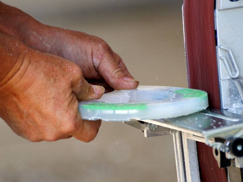 a farrier is adjusting the composite horseshoe to fit the horse's hoof