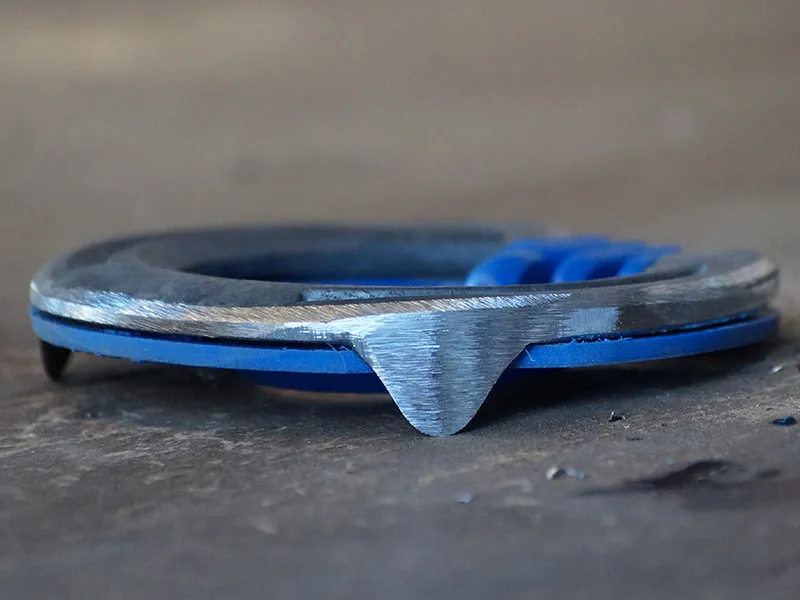 The Mustad horseshoe with shock-absorbing plastic insole is lying on a concrete floor.