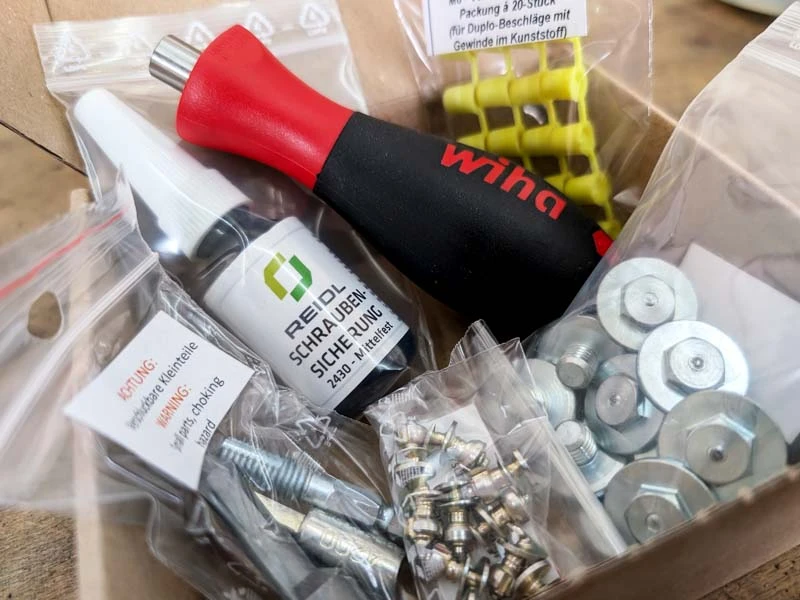 Les différents éléments du kit de grip dans un carton ouvert.