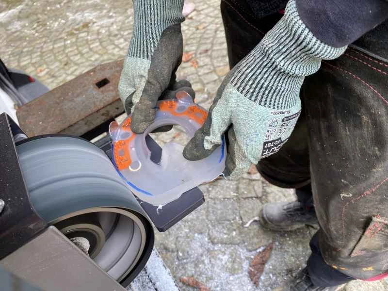 Customizing an alternative horseshoe to the shape of the hoof with the help of the belt grinder.