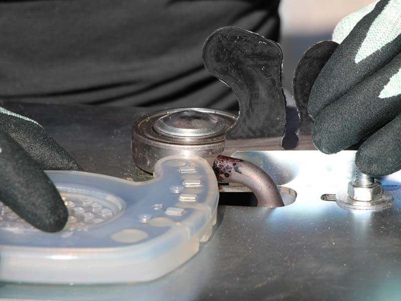 farrier welds an open-toed horseshoe with an adhesive tab using a special farrier welding device