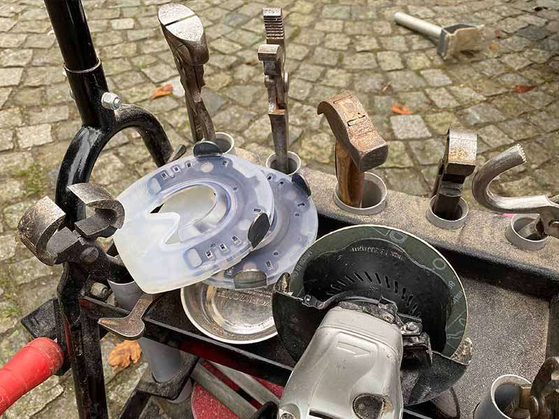 Chariot d'outils de maréchalerie avec pinces, marteau, meuleuse d'angle et fers à cheval alternatifs